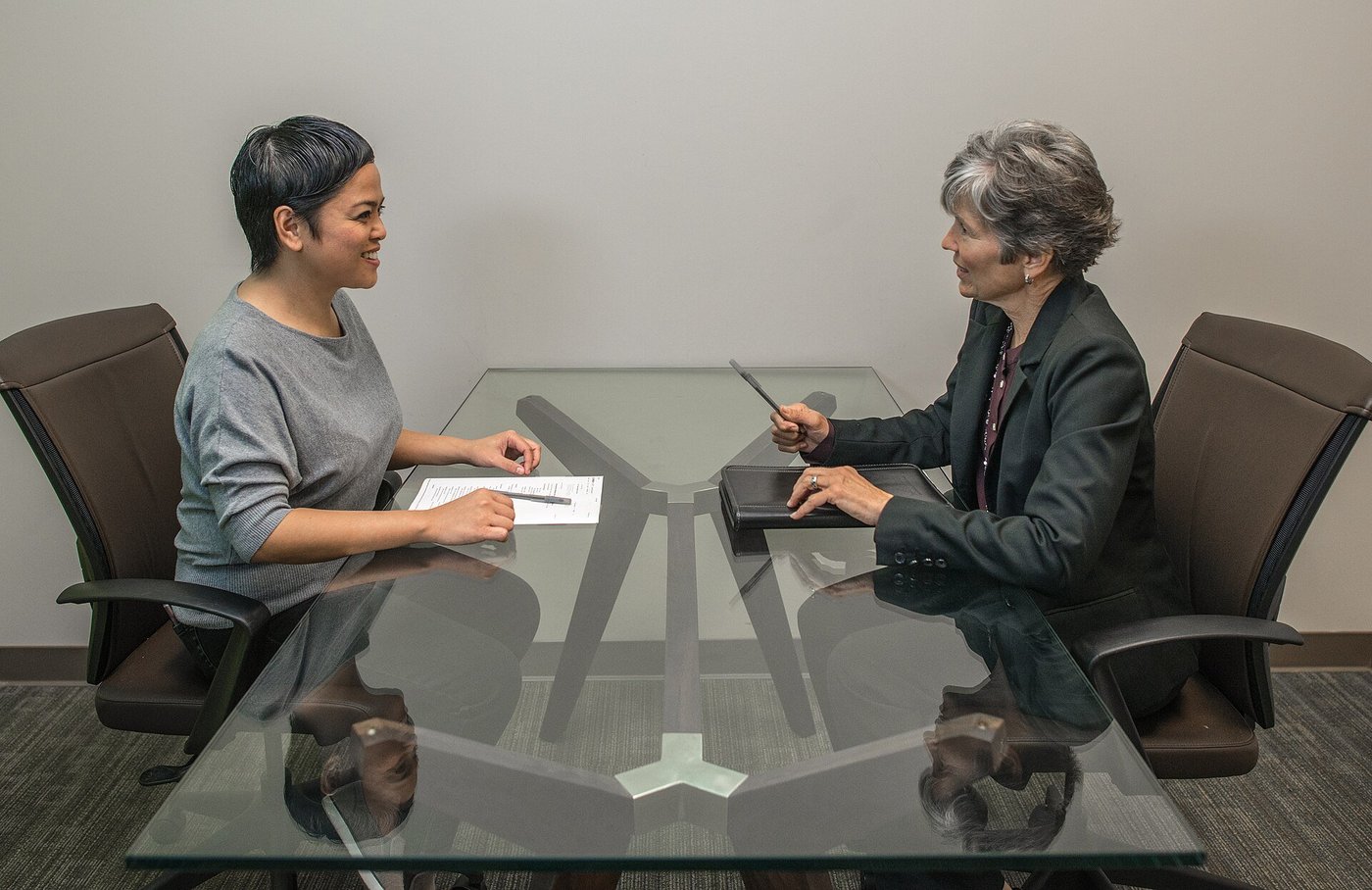 Twee mensen in gesprek aan een tafel tijdens een sollicitatiegesprek.