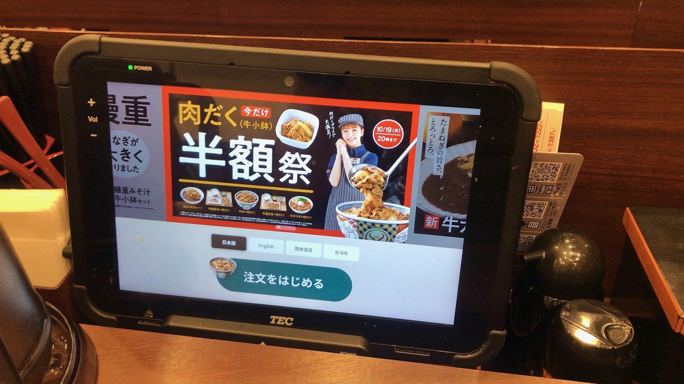 Een tablet met een menukaart op een tafel in een restaurant.