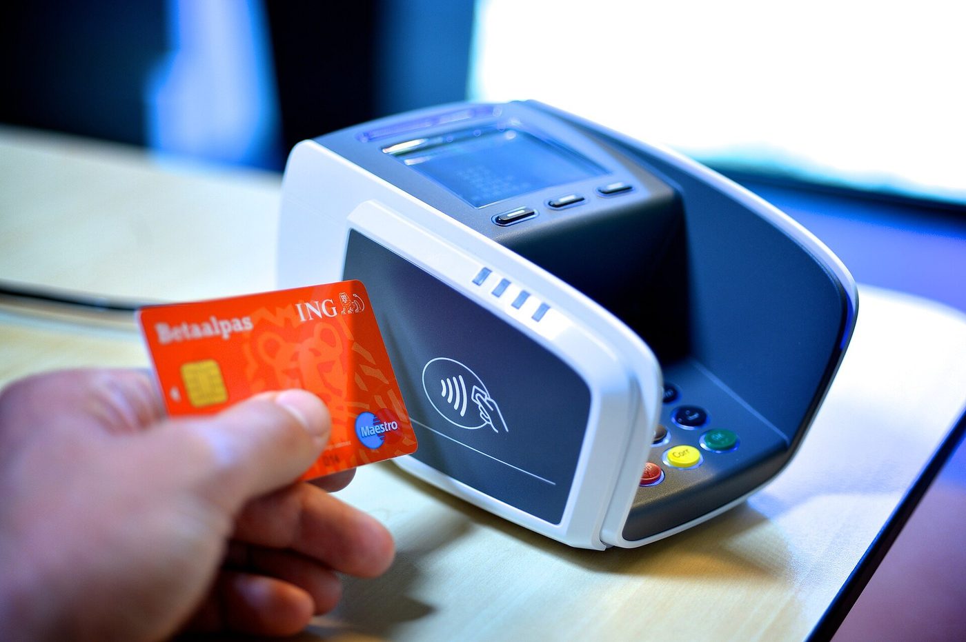 Iemand betaalt contactloos met een telefoon bij een terminal.