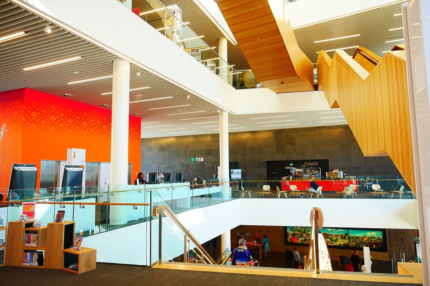 Een moderne bibliotheek met meerdere verdiepingen en open trappen.