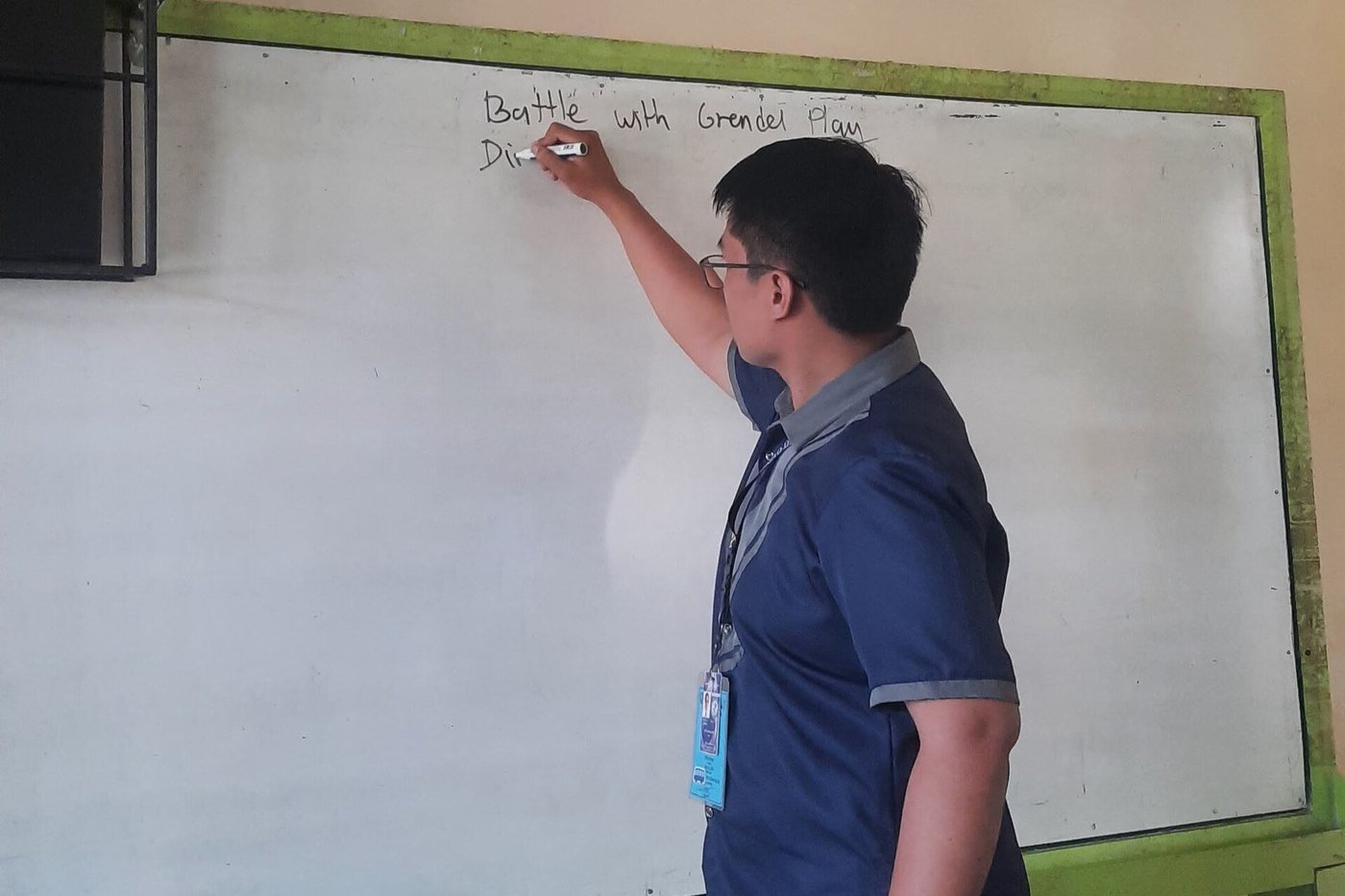 Een docent schrijft een uitleg op een whiteboard in een klaslokaal.
