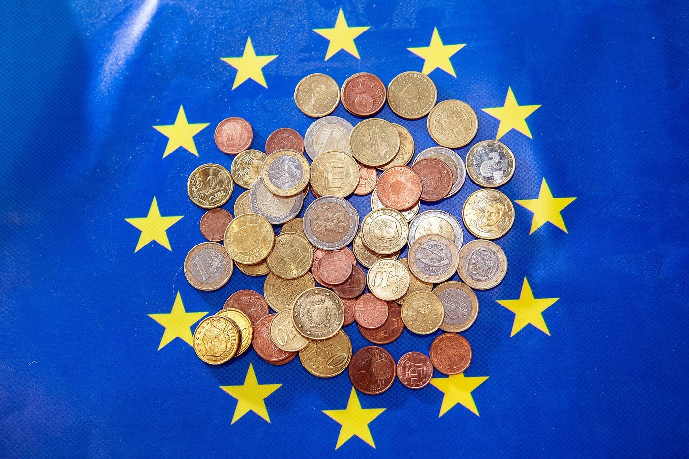 Euromunten op een blauwe achtergrond met gele sterren.