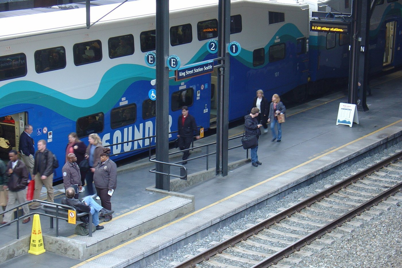 Reizigers op een perron stappen in een trein bij een station.