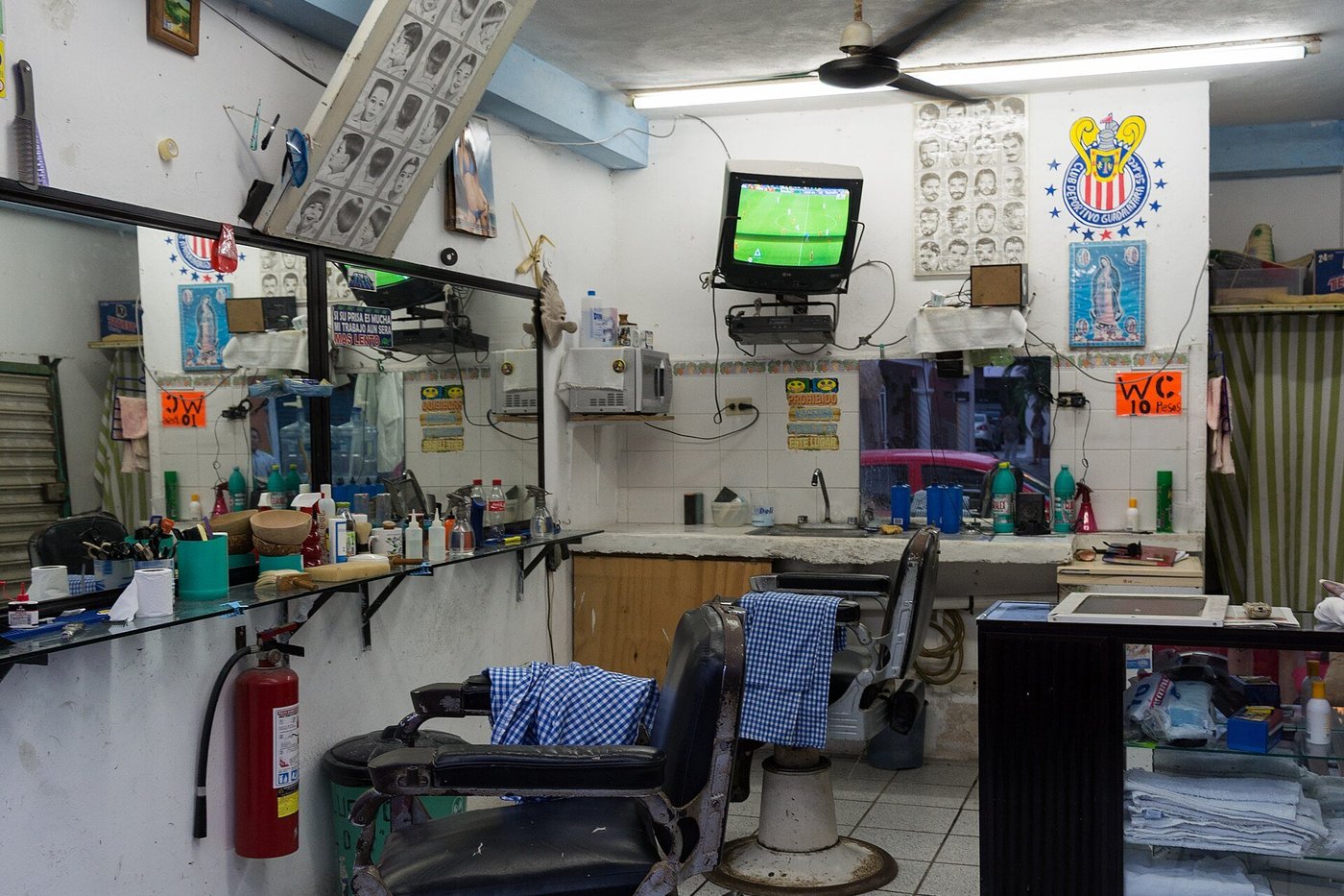 Het interieur van een barbershop met klassieke stoelen, spiegels en gereedschap.