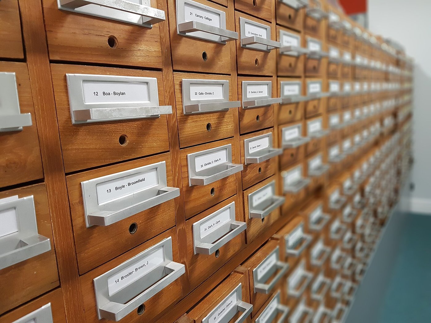 Een houten kaartenbak met tientallen laden vol kaartjes, uit een oude bibliotheek.