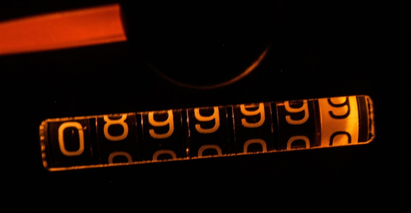 Close-up van een mechanische kilometerteller in een auto.