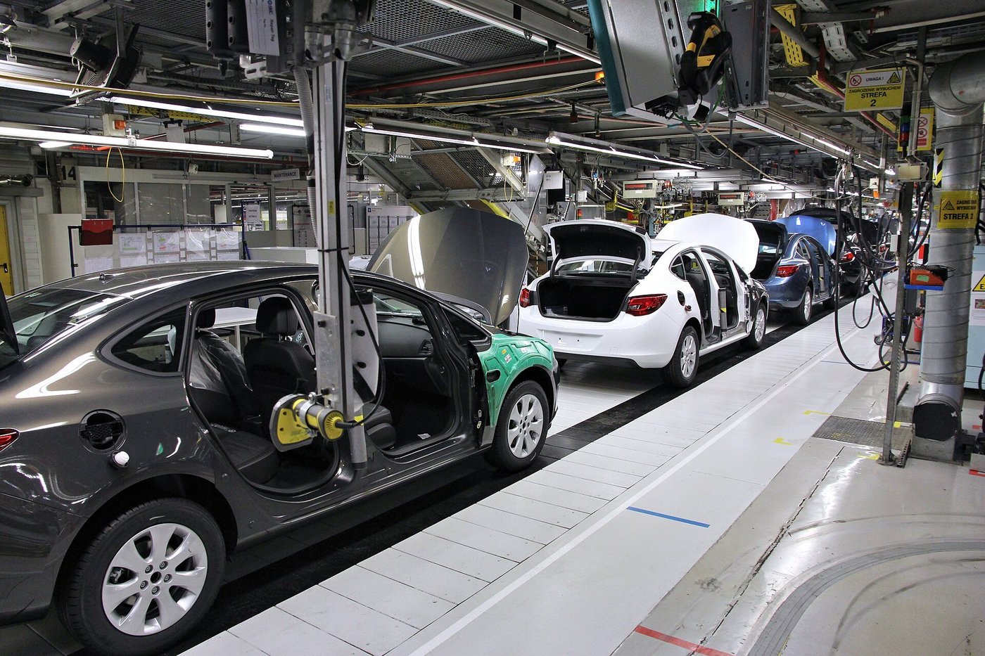 Een lopende band in een autofabriek met carrosserieën in de lijn.