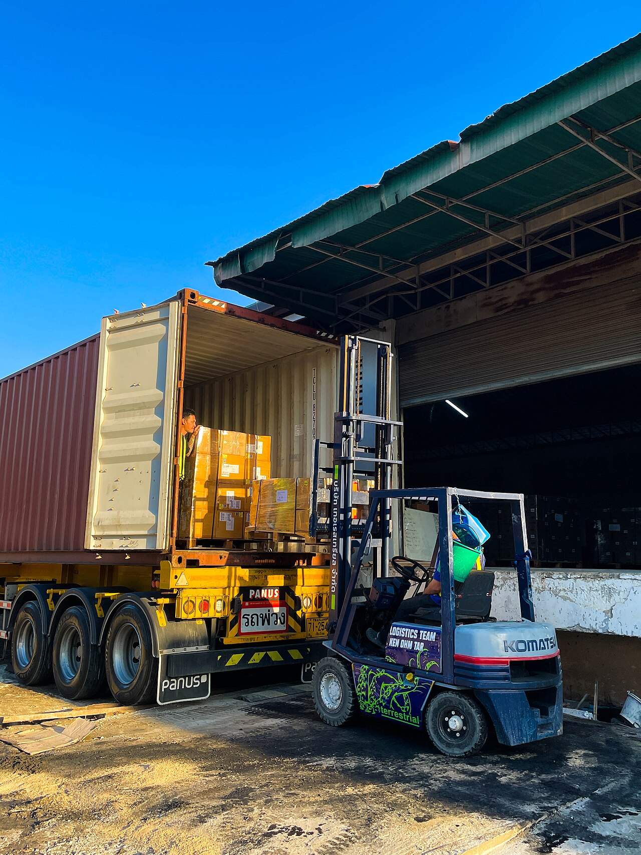 Heftruck laadt een pallet met goederen in een zeecontainer bij een magazijn, een typische uitslag- en verzendhandeling
