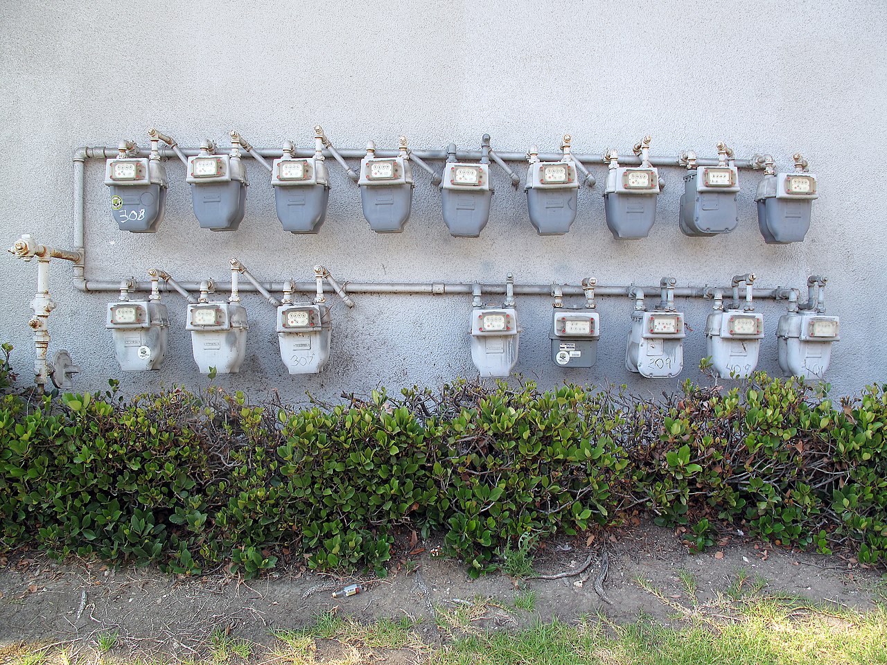 Rij individuele gasmeters in een meterkast van een gebouw met meerdere units