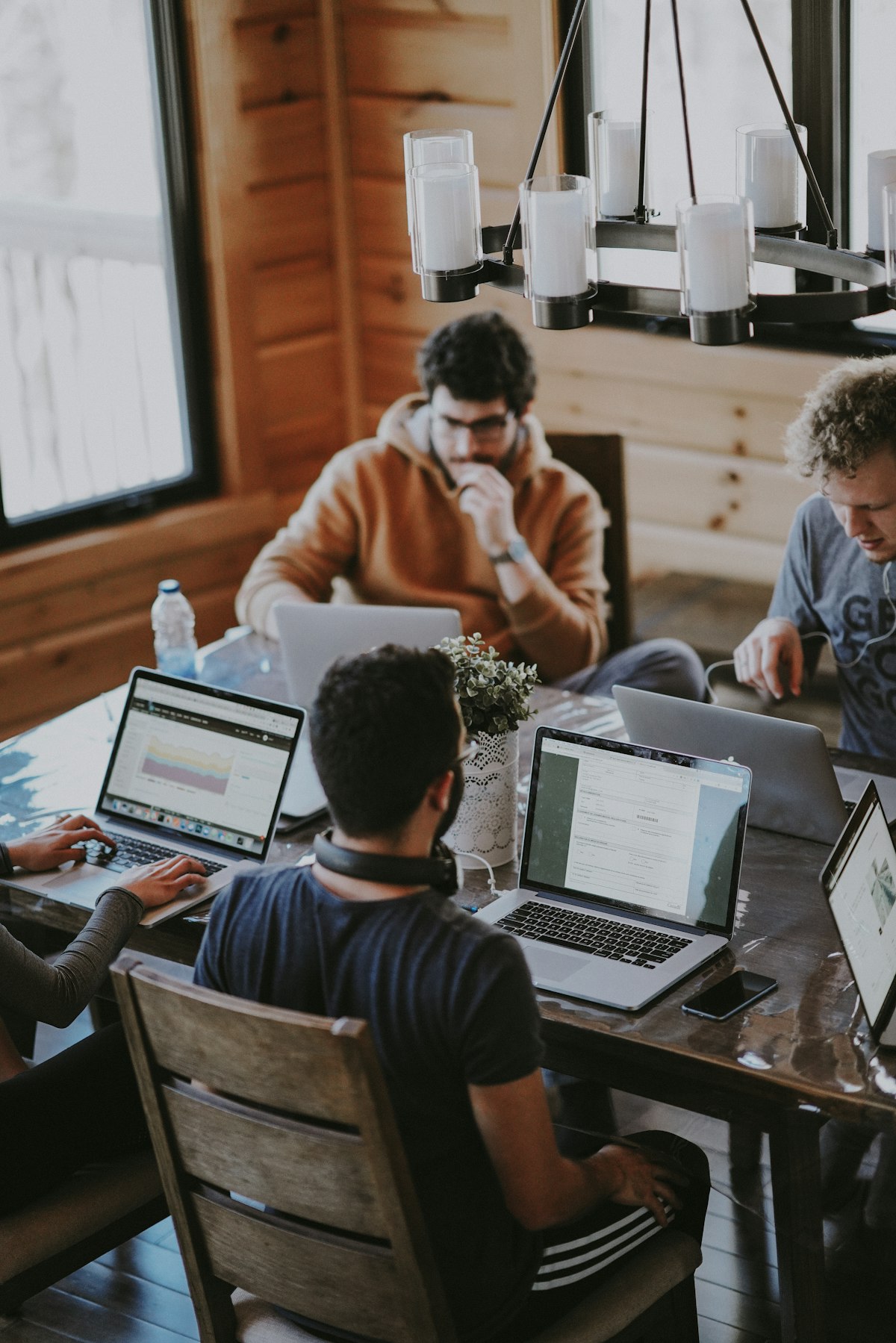 Een team werkt samen rond een tafel met laptops, het soort kennismaken en wegwijs worden dat een goede onboarding op gang brengt