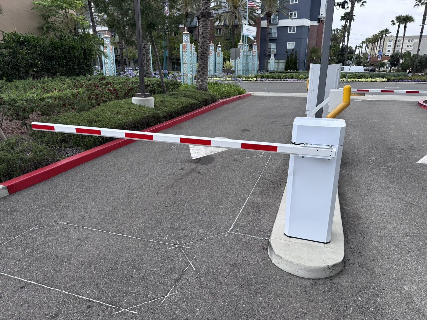 Een slagboom bij de inrit van een parkeerterrein, gezien vanaf de weg.