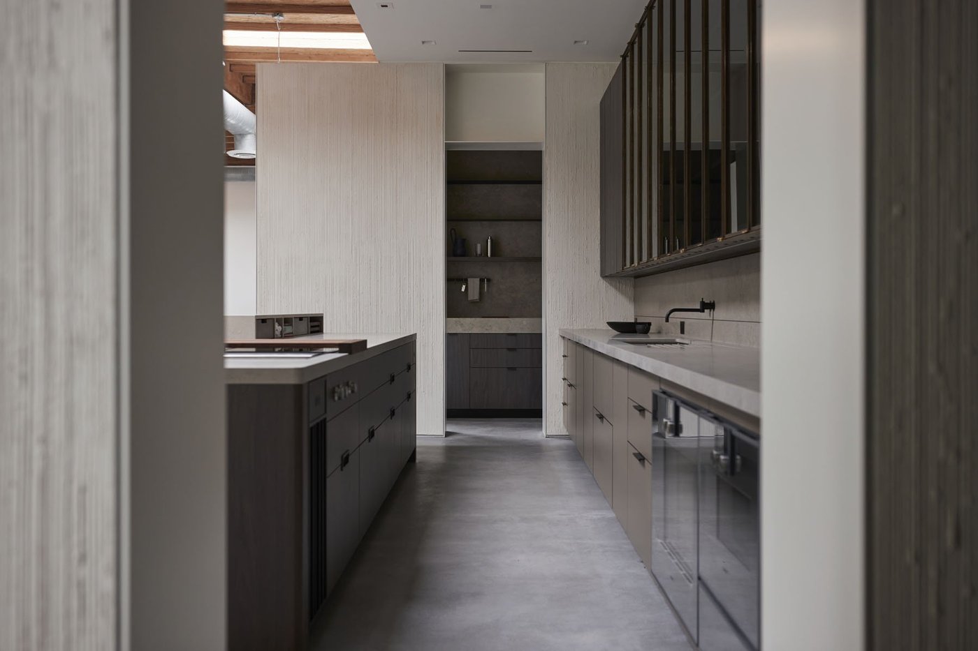 Een strakke moderne keuken in een showroom met houten kasten en een kookeiland.