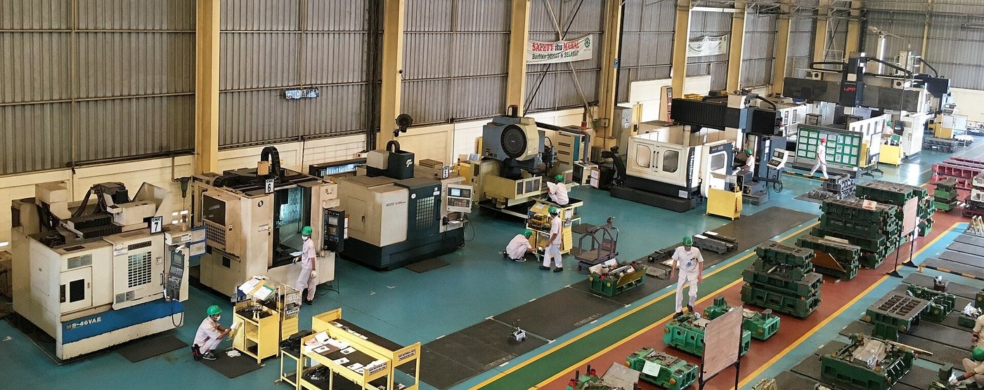 Een productiehal met rijen CNC-machines en werkplekken ertussen.