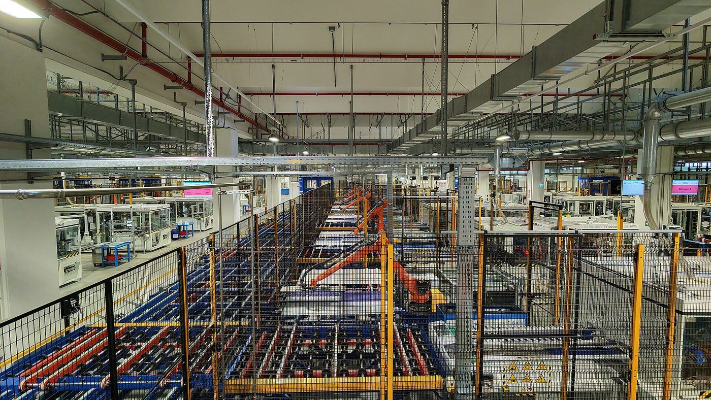 Overzicht van een geautomatiseerde productielijn in een grote fabriekshal.