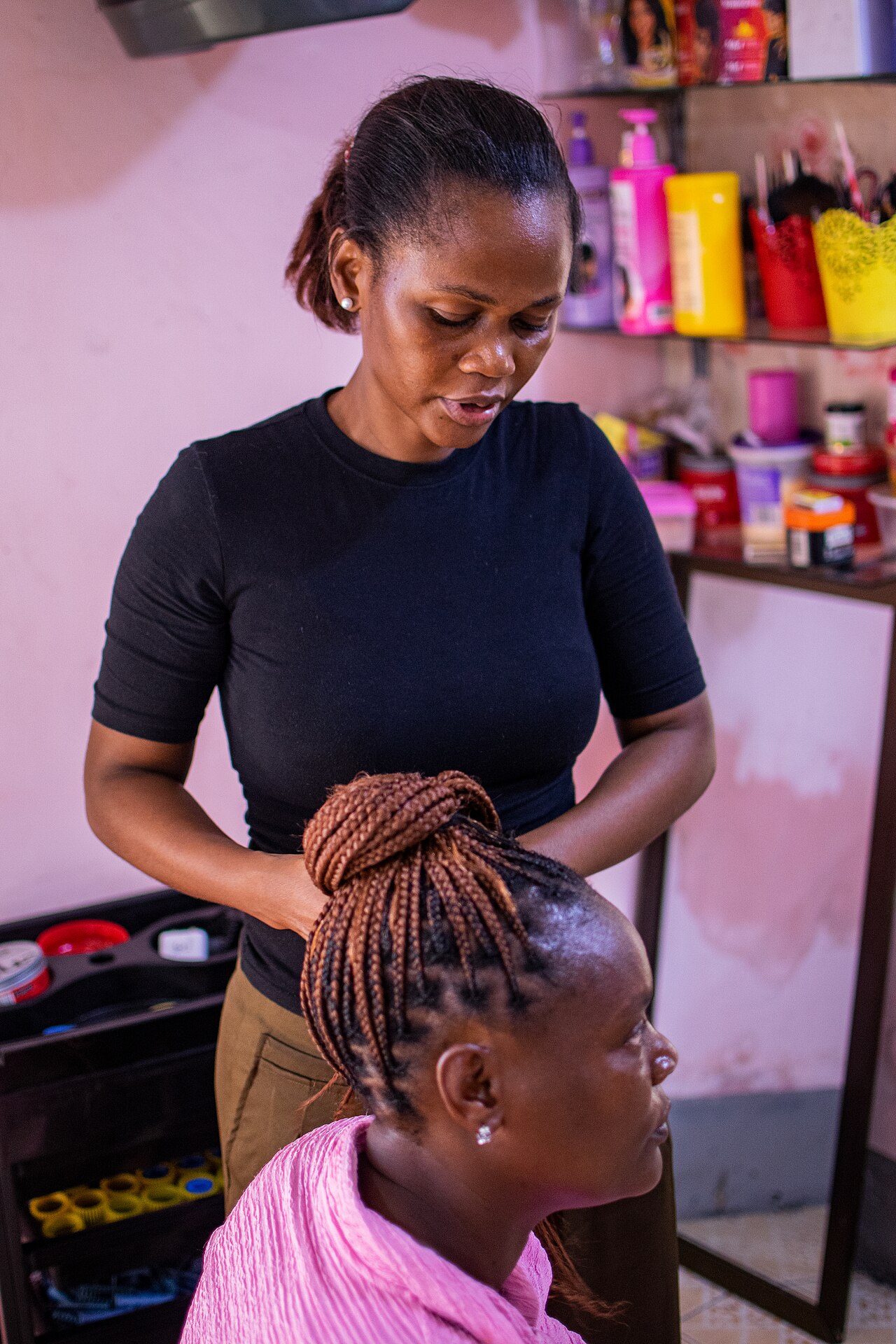 Kapster die een klant in een salon behandelt, een sector waarin per medewerker en per stoel afspraken worden ingepland