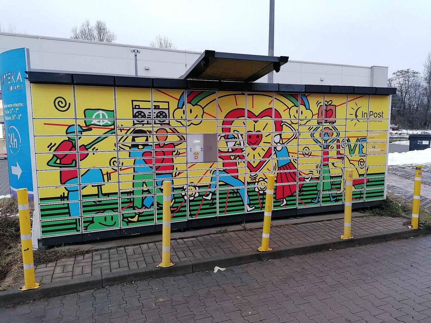 Een beschilderde pakketautomaat met kluisjes langs een straat.