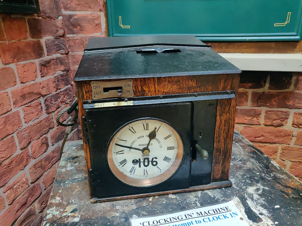 Mechanische prikklok met een rek vol urenkaarten, de klassieke voorganger van de digitale urenregistratie