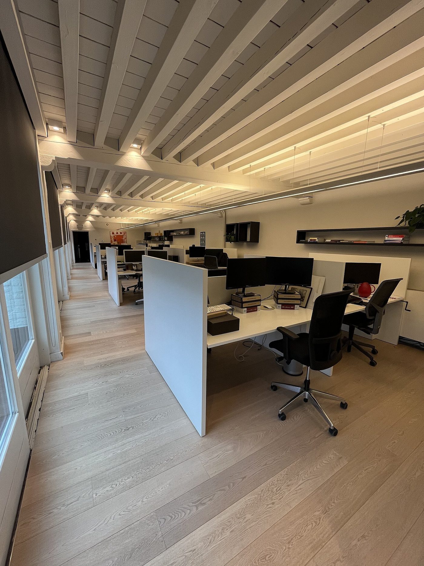 Een modern kantoor met werkplekken en een scheidingswand.