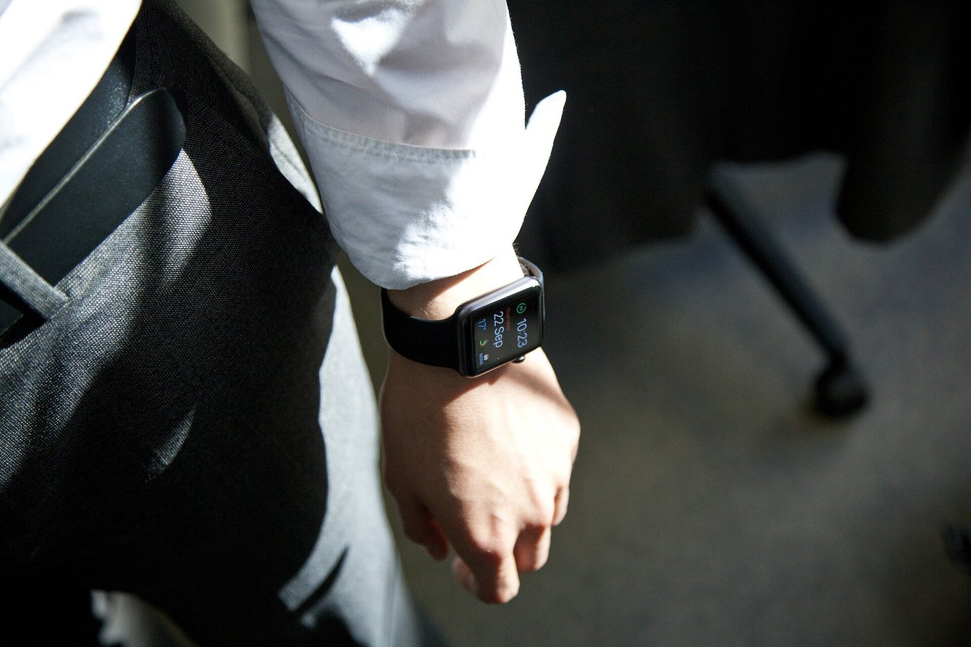 Een man in overhemd met een smartwatch om zijn pols aan een bureau.