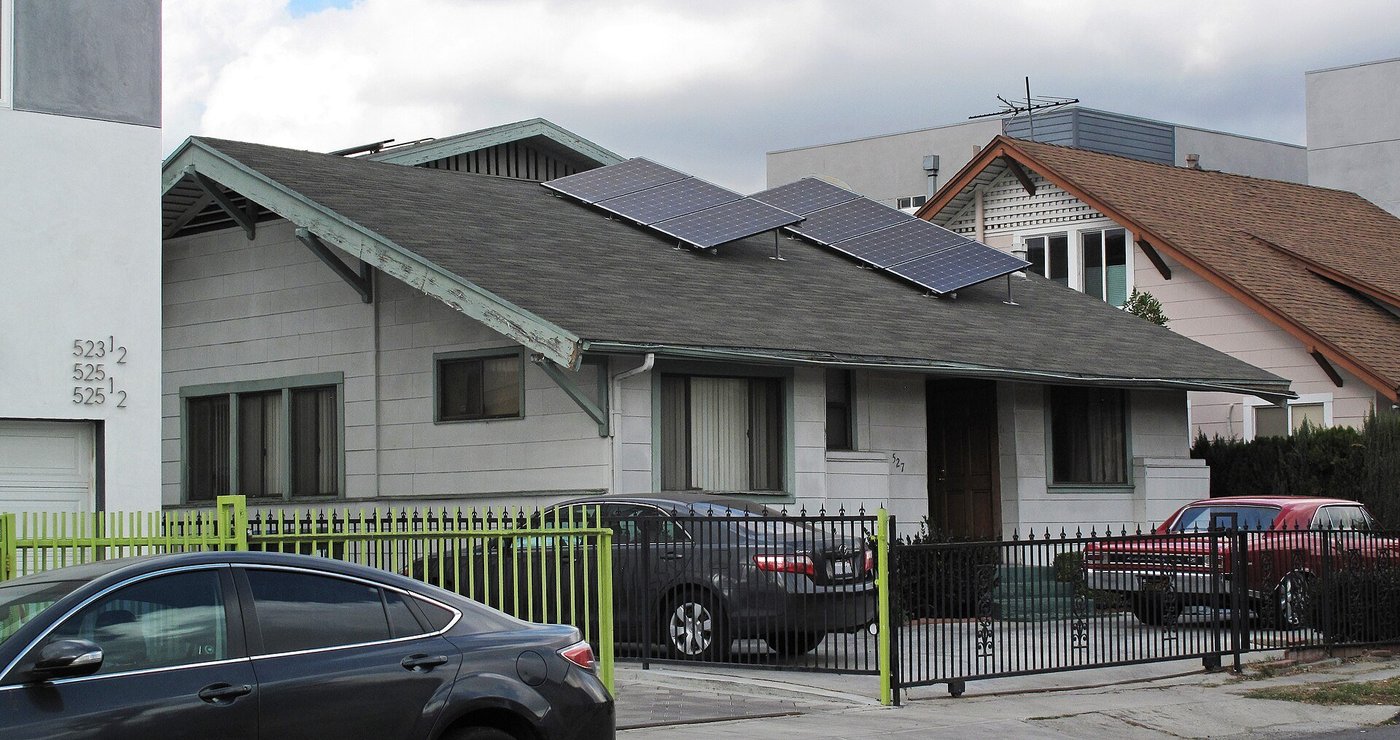 Een woning met zonnepanelen op het schuine dak, gezien vanaf de straat.