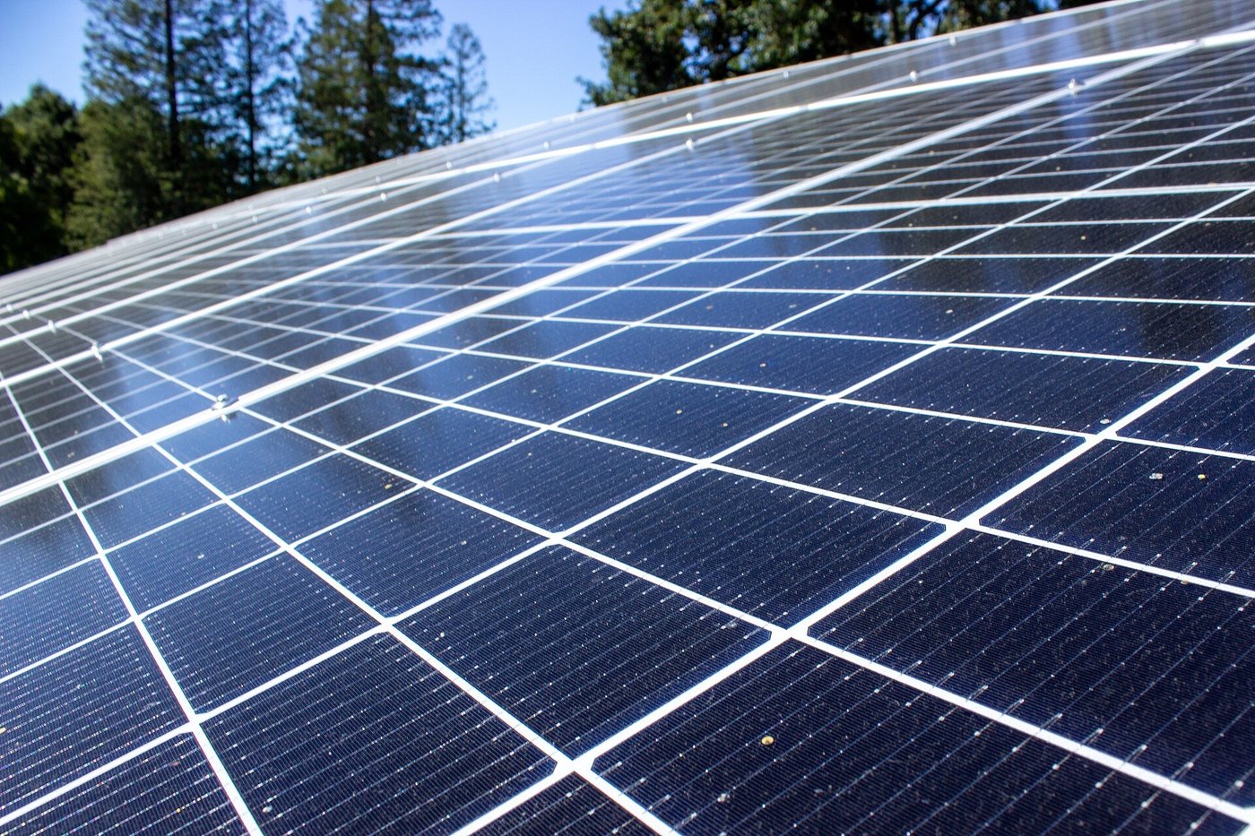 Een close-up van zonnepanelen op een dak, met de cellen en de lijnen van de panelen zichtbaar.